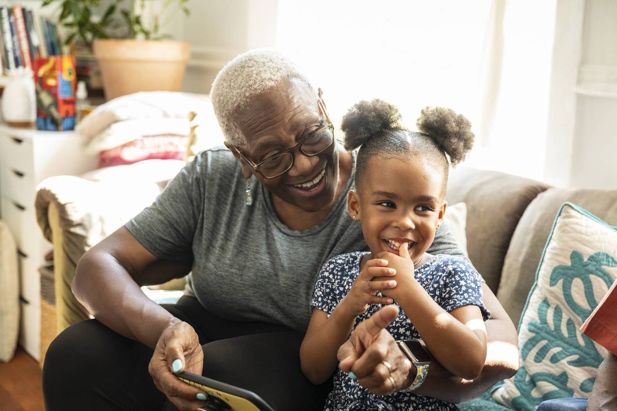 senior and granddaughter using smart phone