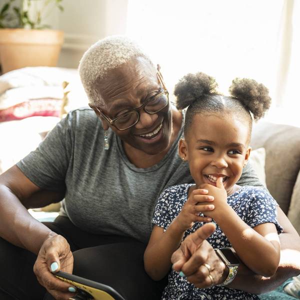 senior and granddaughter using smart phone