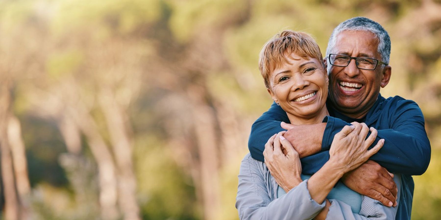 senior couple hugging in a garden while on romantic outdoor date