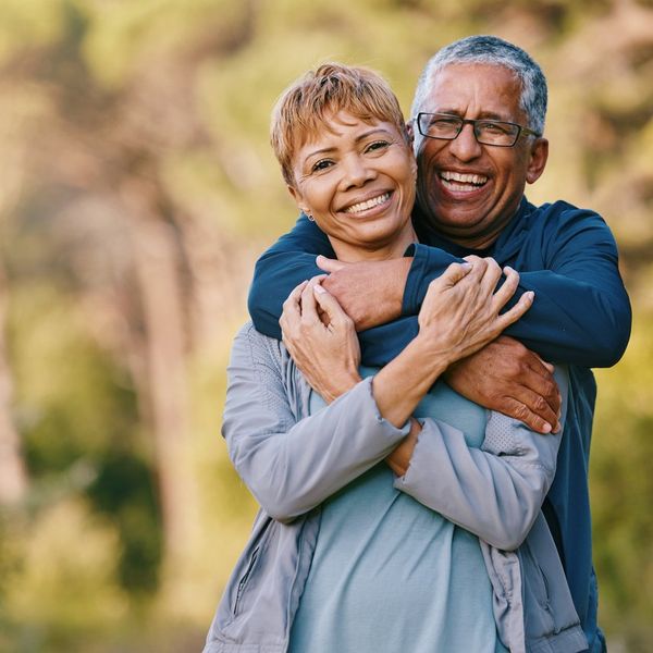 senior couple hugging in a garden while on romantic outdoor date