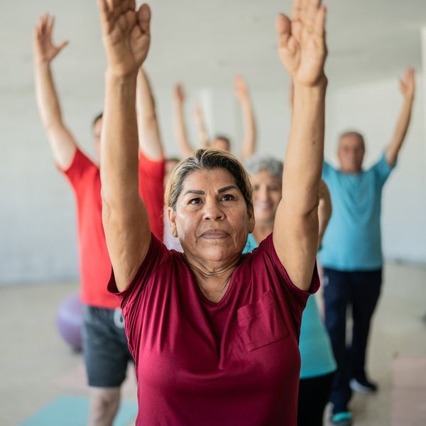 Senior woman stretching with classmates at the yoga studio