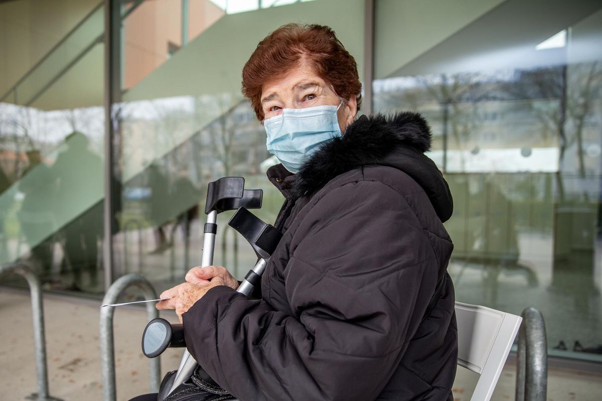 Senior woman waiting outside a Hospital for a COVID-19 vaccination
