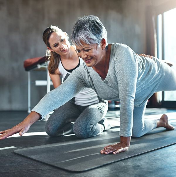 senior woman working out with her physiotherapist due to multiple sclerosis