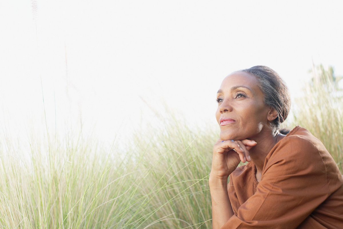 Serene woman sitting in sunny field