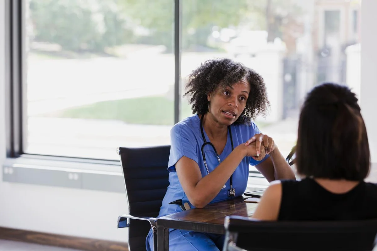 Serious female doctor talks with patient