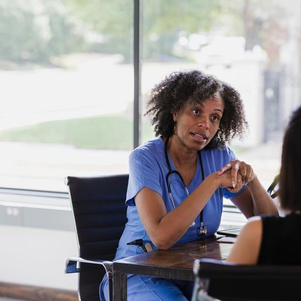Serious female doctor talks with patient