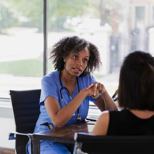 Serious female doctor talks with patient