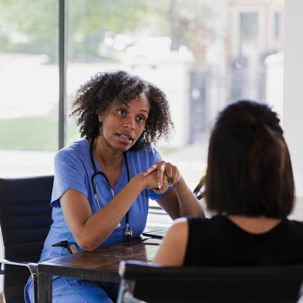 Serious female doctor talks with patient