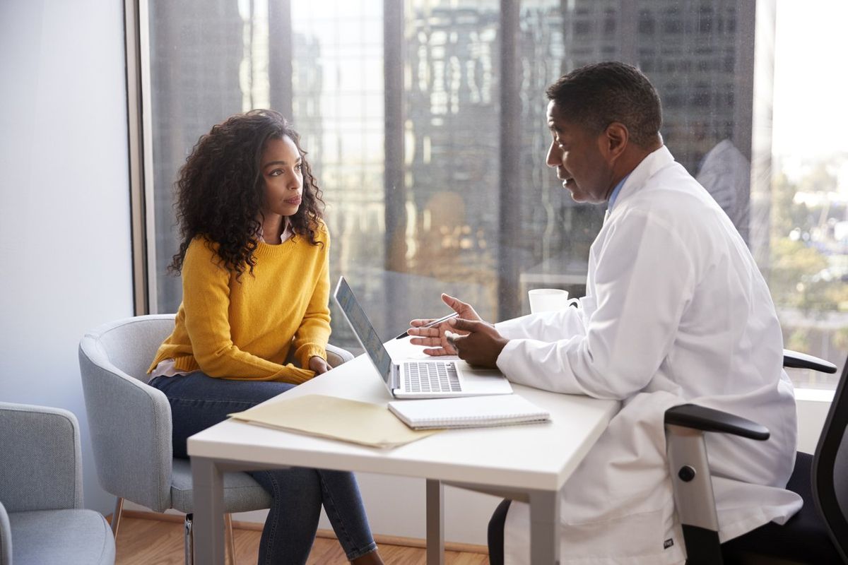 Serious Woman Having Consultation With Male Doctor