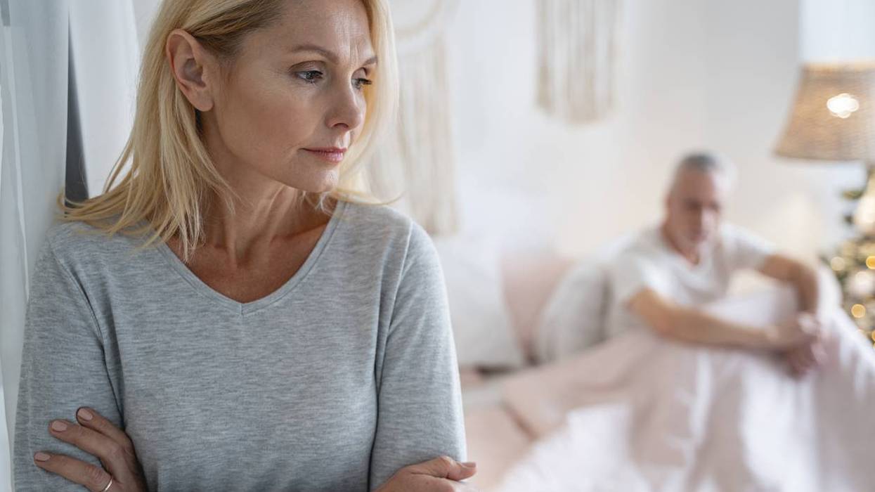 Serious worried woman standing with crossed arms after quarreling with man
