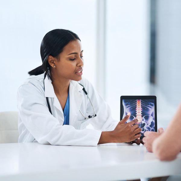 Shot of a young doctor using a digital tablet during a consultation with a senior woman