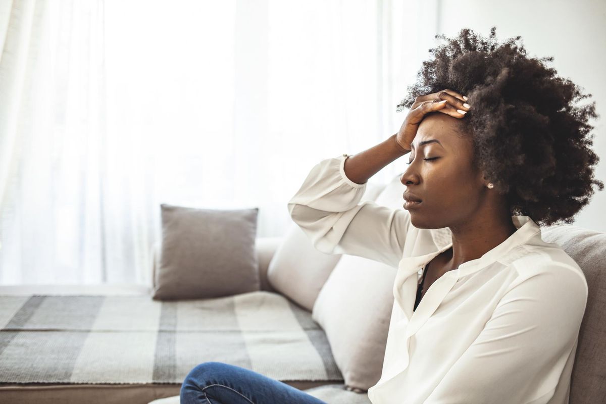 Shot of a young woman suffering from a headache