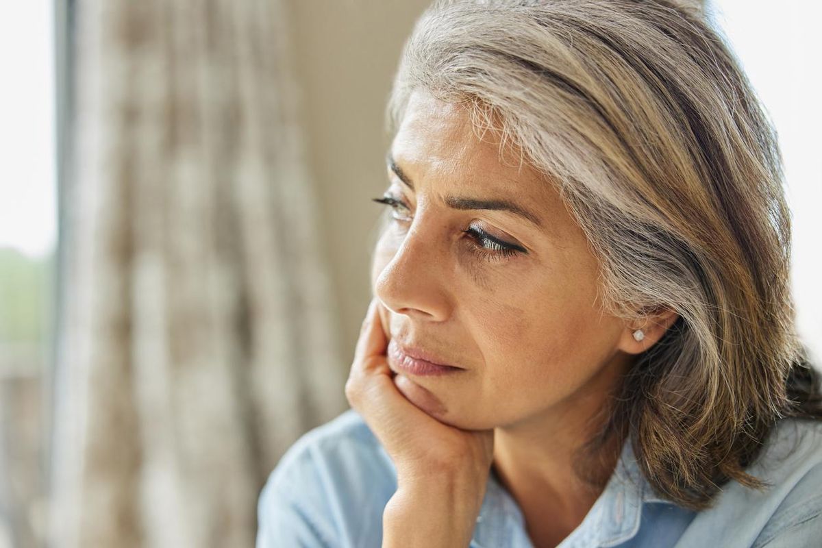 Shot Of Thoughtful Mature Woman Looking Out Of Window