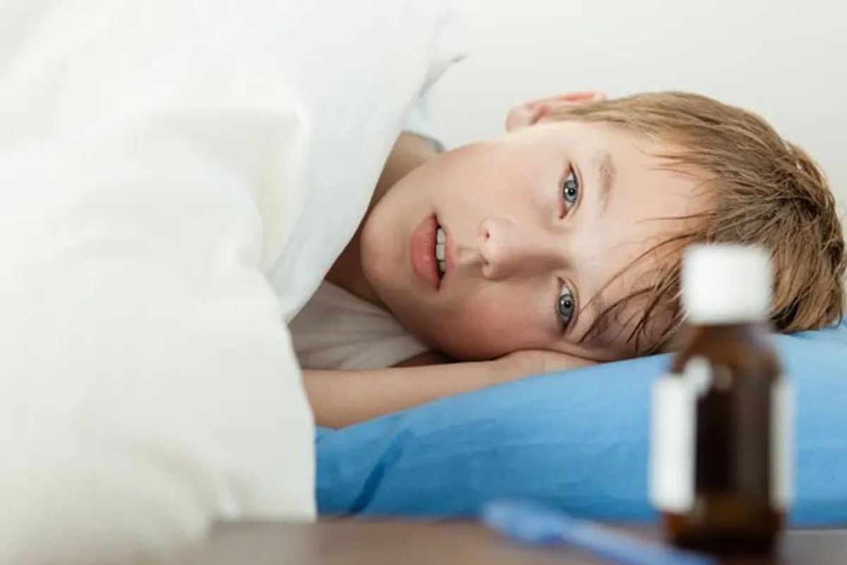 sick boy laying down in bed