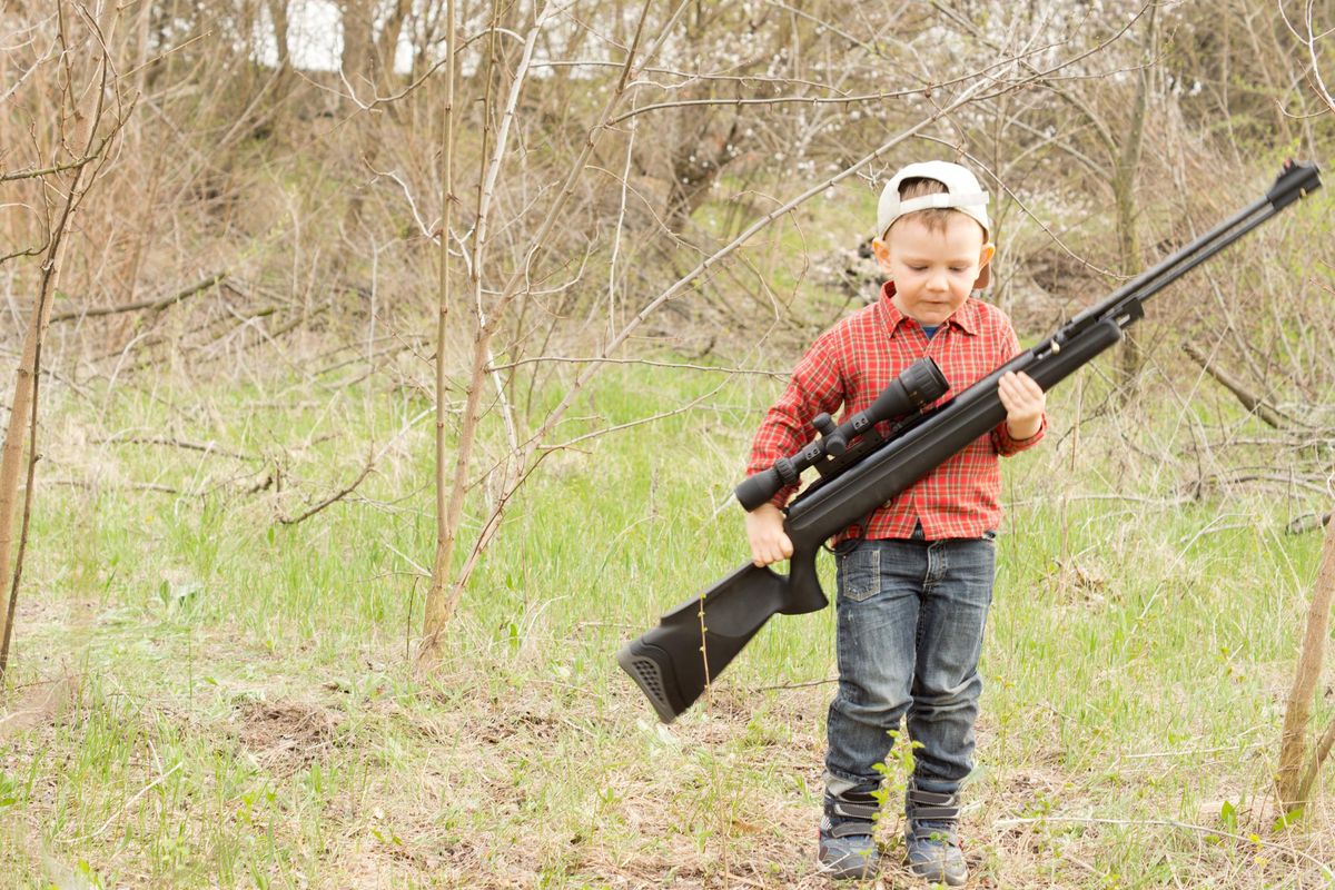 Small boy carrying a rifle
