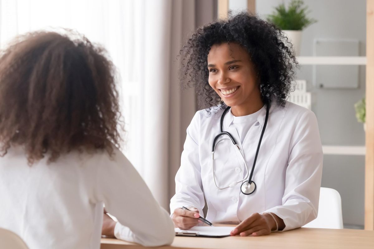 Smiling doctor talking to female patient