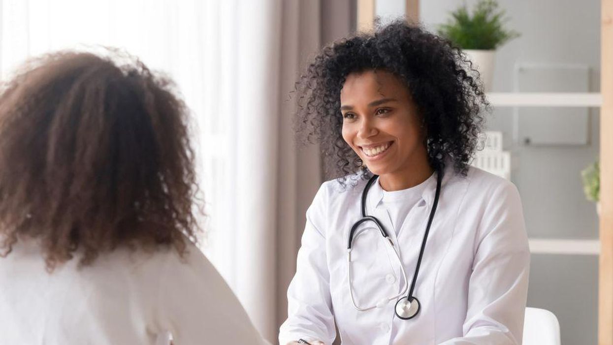 Smiling doctor talking to female patient