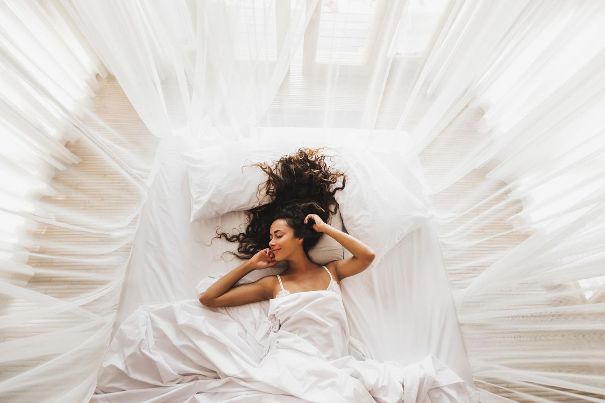 smiling girl awakening in white bed