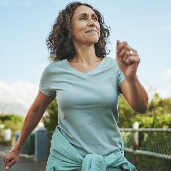 Smiling mature woman out for a power walk in summer