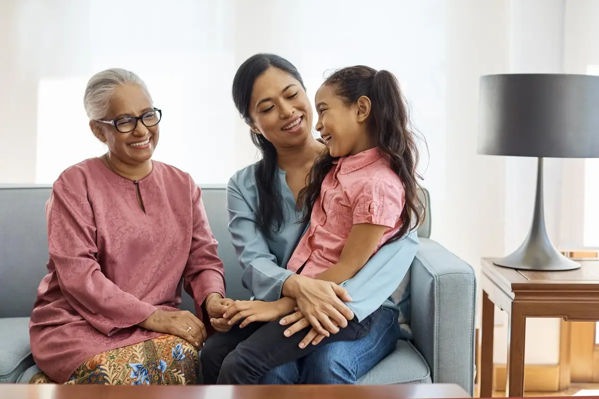 Smiling multi-generational family sitting at home