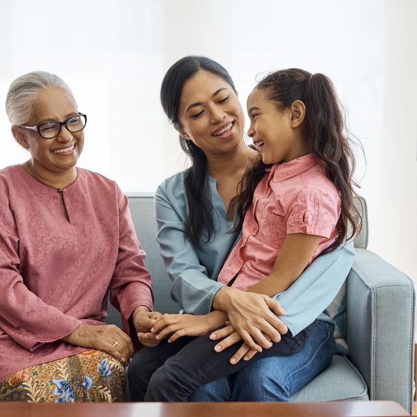 Smiling multi-generational family sitting at home