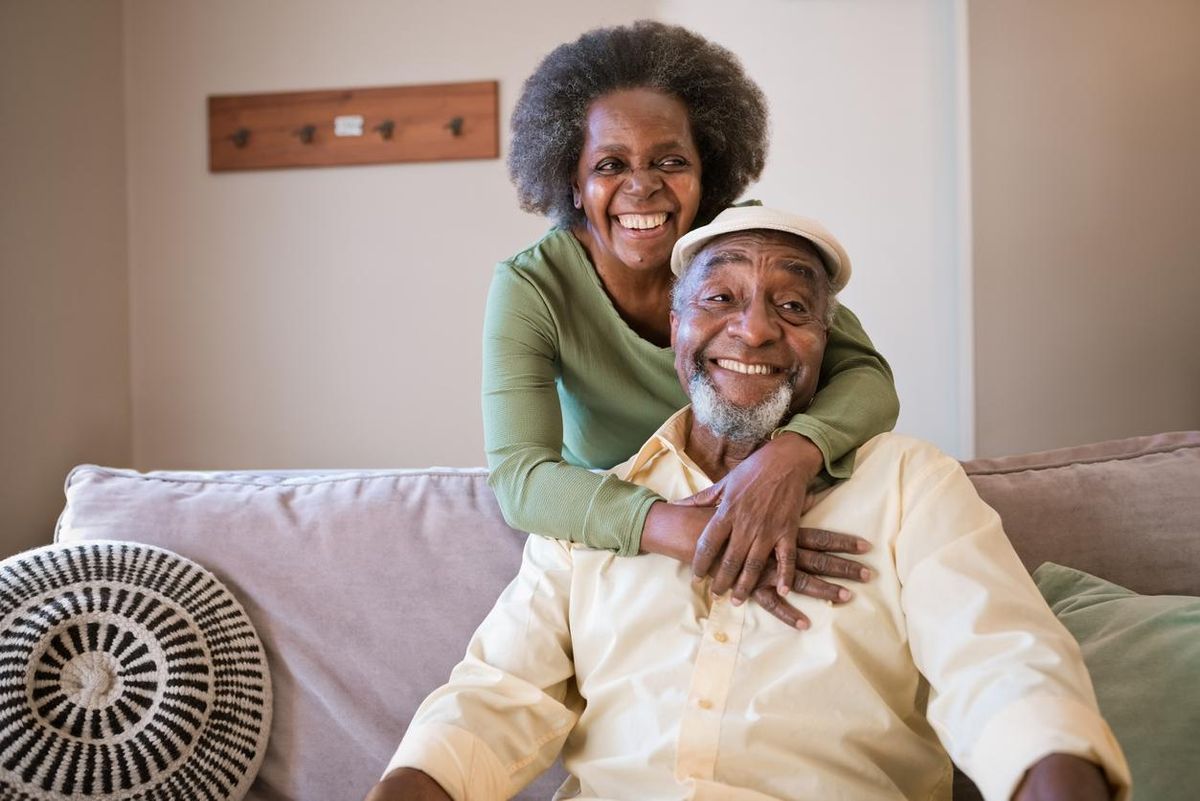 Smiling senior couple in living room at home