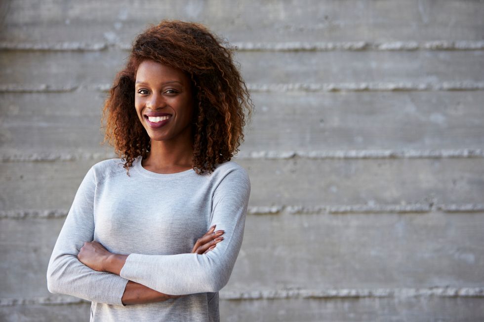 smiling woman in her thirties, crossing her arms