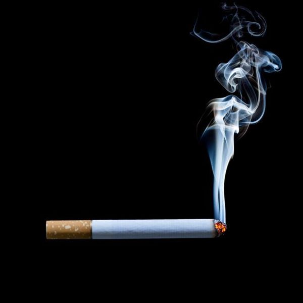 Smoking cigarette on black background