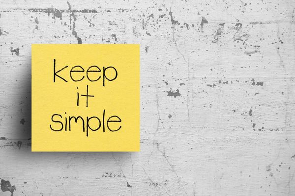 Sticky note on concrete wall, that says Keep it simple