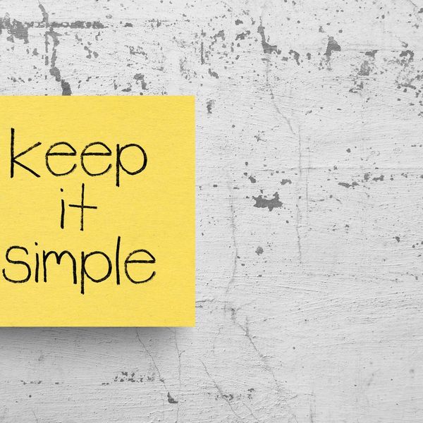 Sticky note on concrete wall, that says Keep it simple