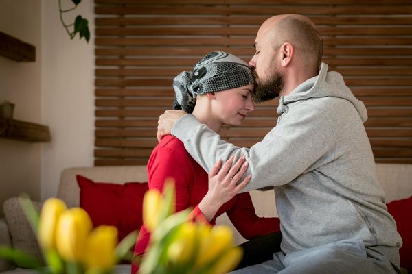 Supportive husband kissing his wife, cancer patient