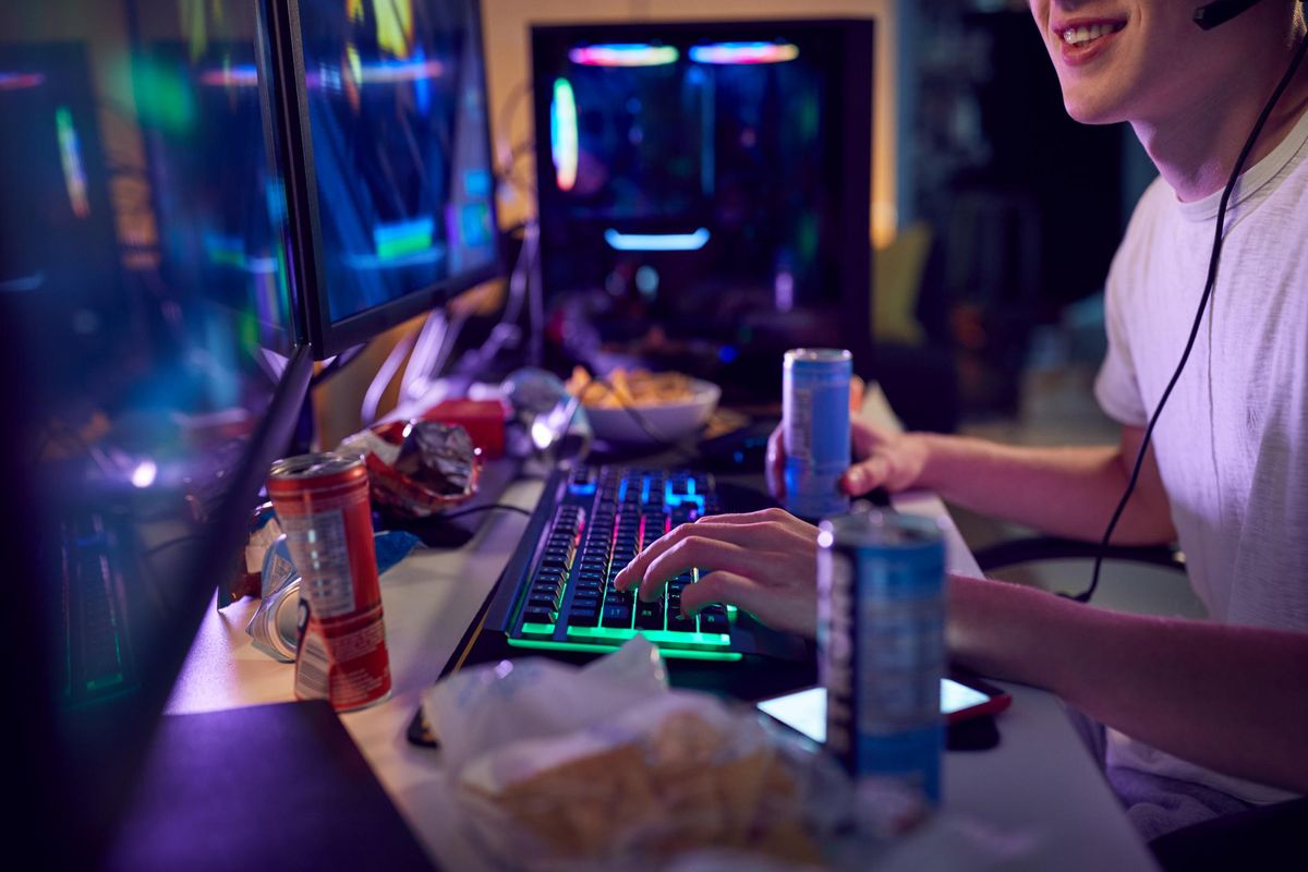 Teenage Boy Drinking Caffeine Energy Drink Gaming At Home