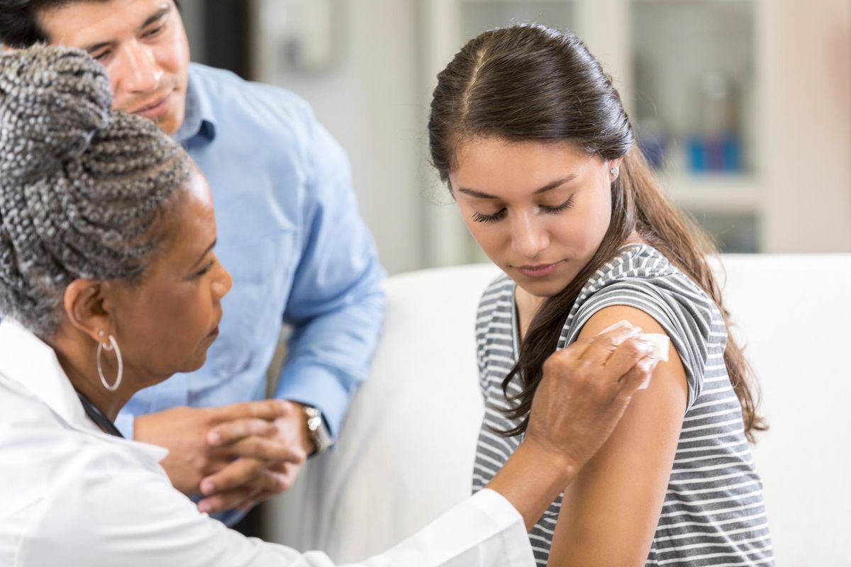 Teenage girl prepares for vaccination at doctor