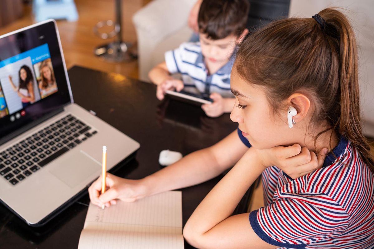 Teenage girl studying with video online lesson