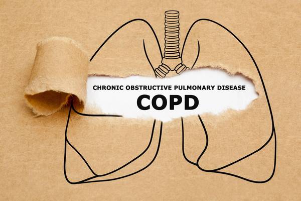 Text Chronic Obstructive Pulmonary Disease COPD appearing behind torn brown paper in human lungs drawing