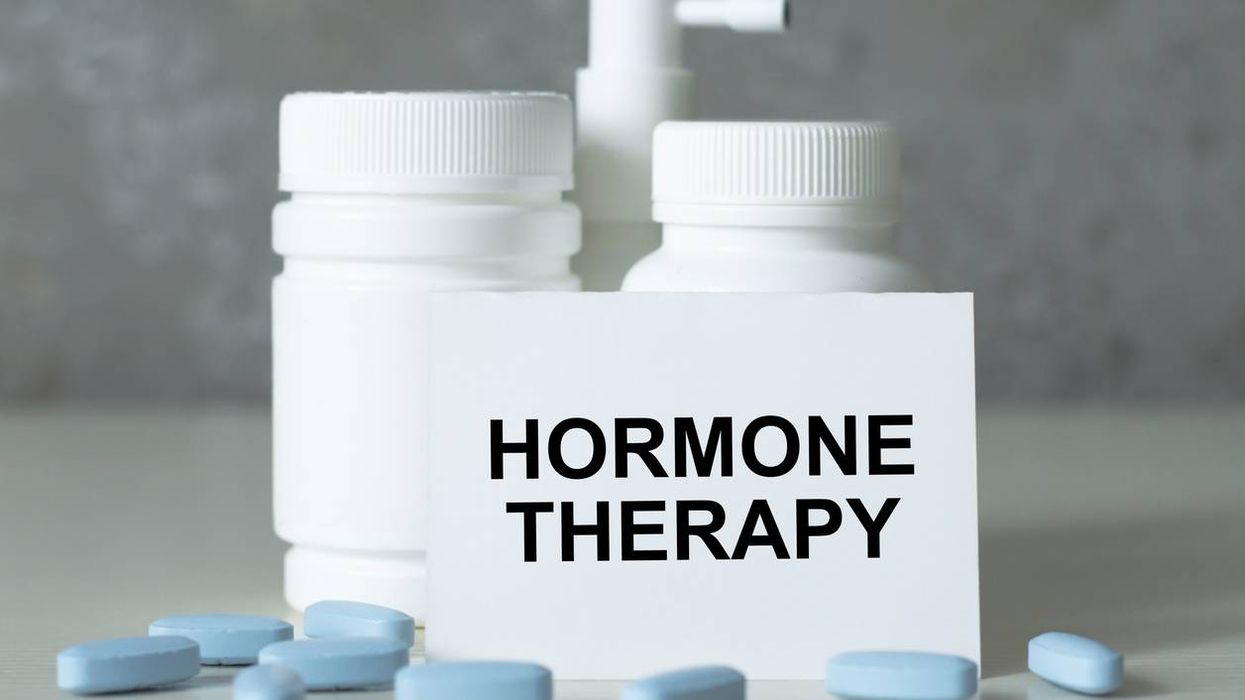 text hormone THERAPY on a white card next to medicine jars and scattered blue pills