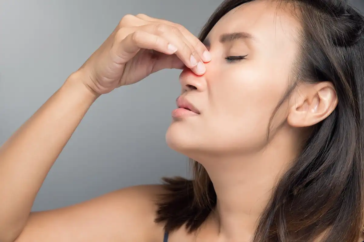 The asian woman hurts her nose because she has nasal polyps