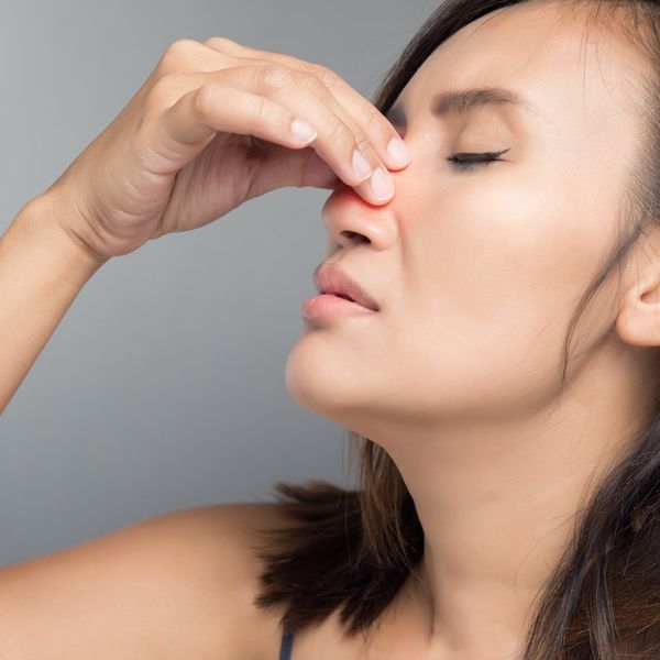 The asian woman hurts her nose because she has nasal polyps
