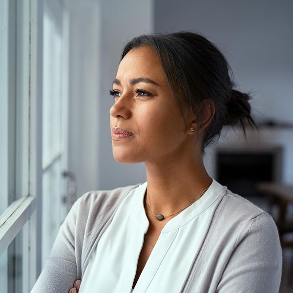 Thoughtful black woman looking outside window