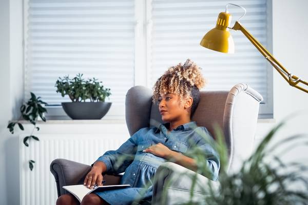 Thoughtful pregnant owner resting in new office
