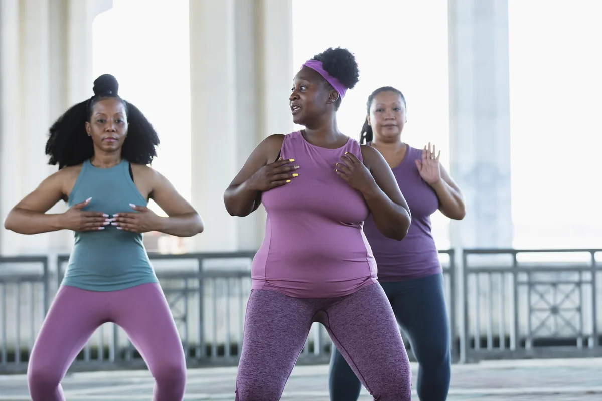 Three multiracial women practicing tai chi in