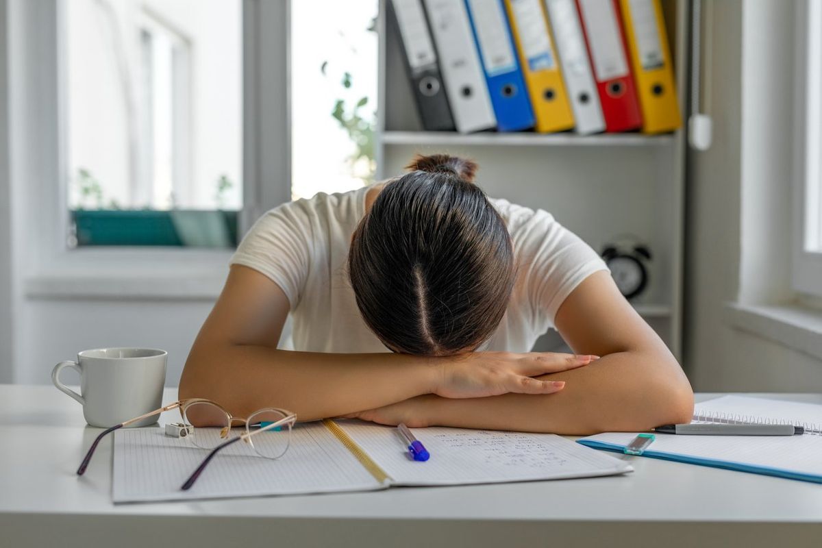 Tired girl sleeping at her desk