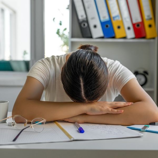 Tired girl sleeping at her desk
