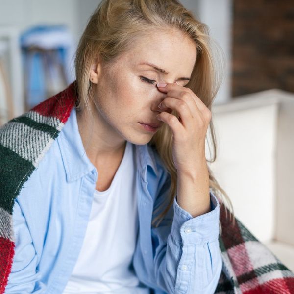 Tired woman with closed eyes touching nose bridge