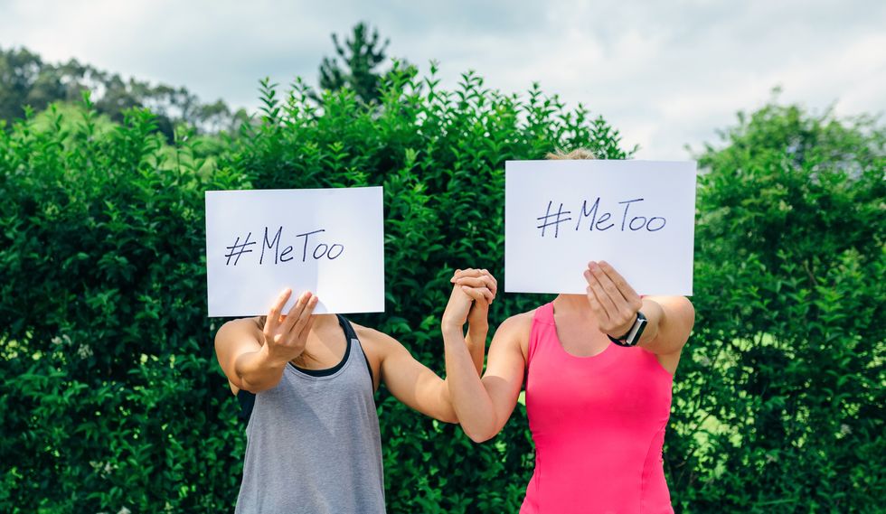Two unrecognizable young women showing poster with metoo hashtag