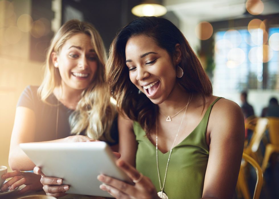 two women looking at a dating app on a tablet