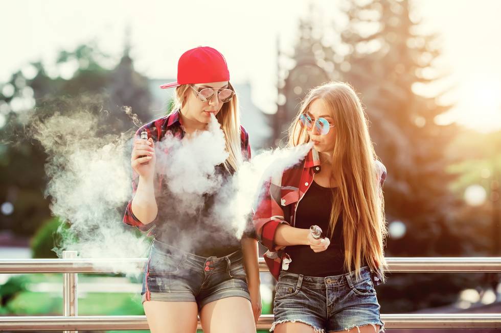 Two women vaping outdoor