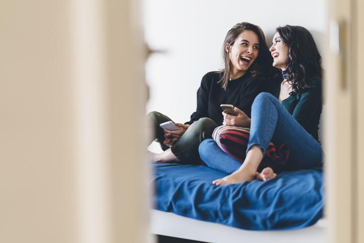 Two young women friends are talking and laughing happily
