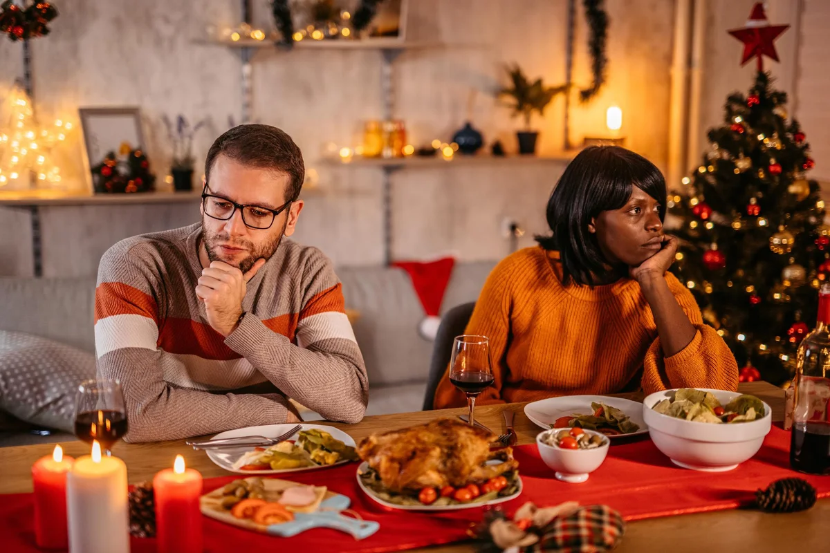 Unhappy couple ignoring each other at Christmas dinner