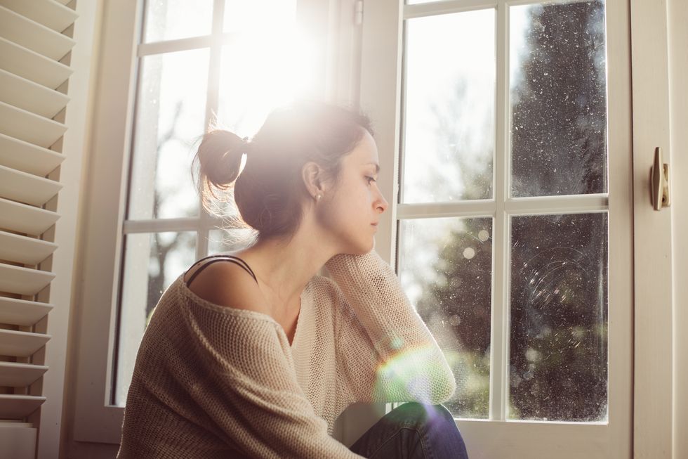 Unhappy woman sitting near the window